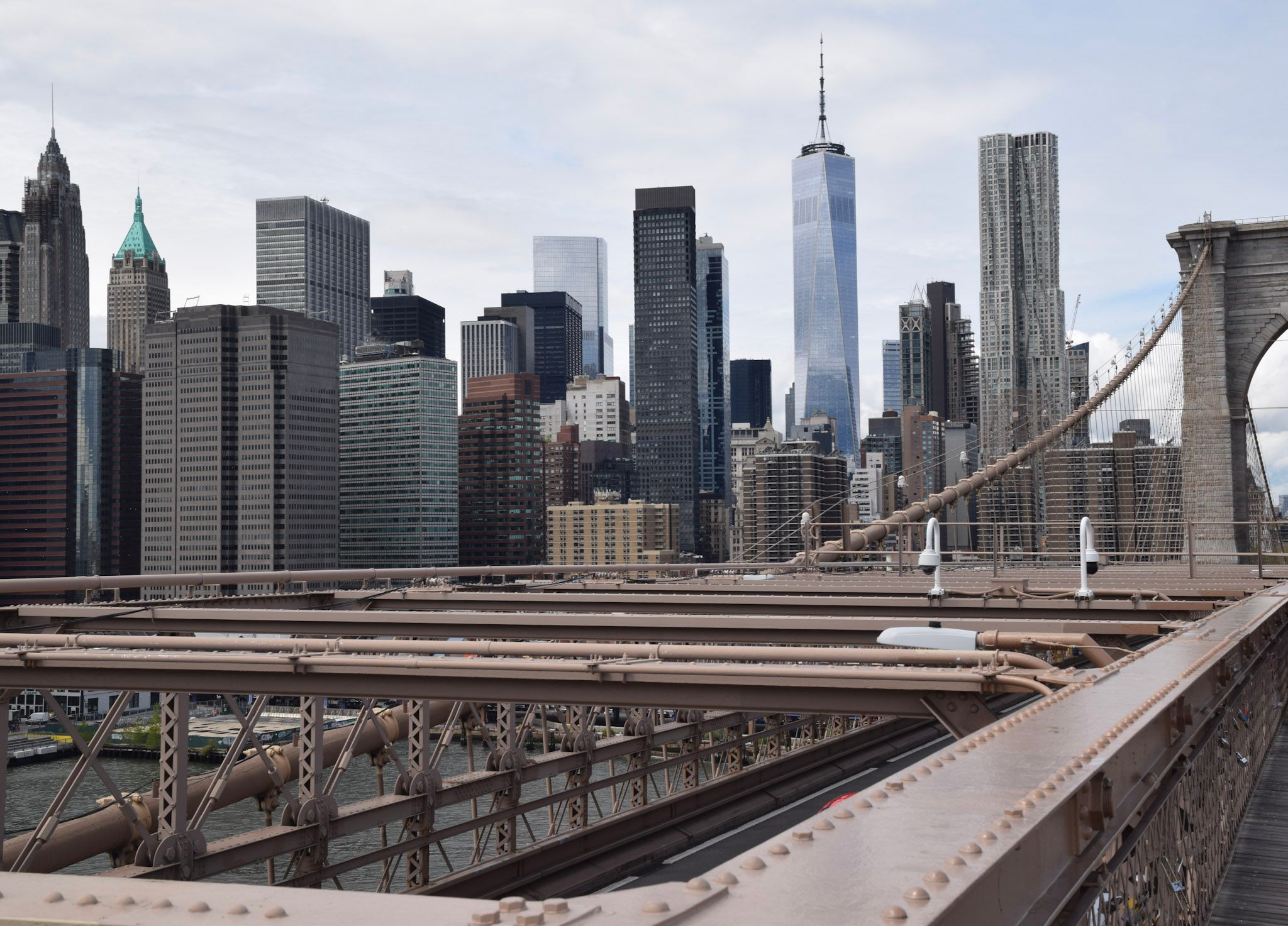 El skyline del Lower Manhattan visto desde la pasarela del puente de Brooklyn, con la torre de piedra y los cables a la derecha